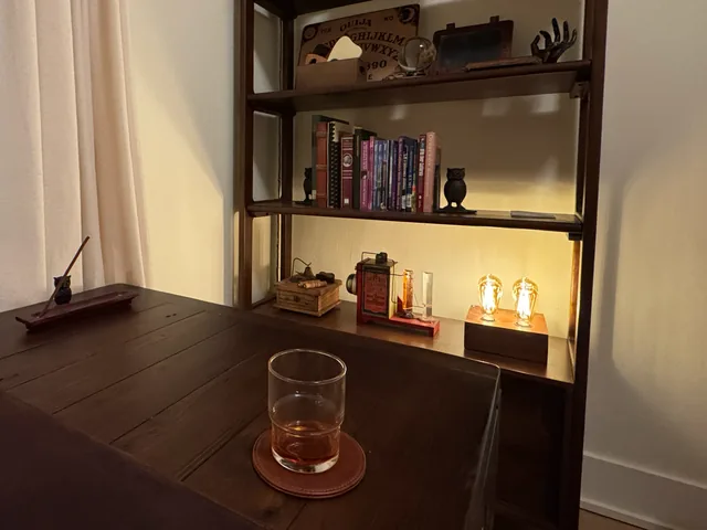 books, keepsakes, and a glowing lamp beside the wooden desk in Dunsmuir